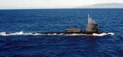 A photograph of the USS William H. Bates (SSN-680) submerged in the ocean with light filtering down from the surface. The author, Darin Detwiler, served on this submarine.
