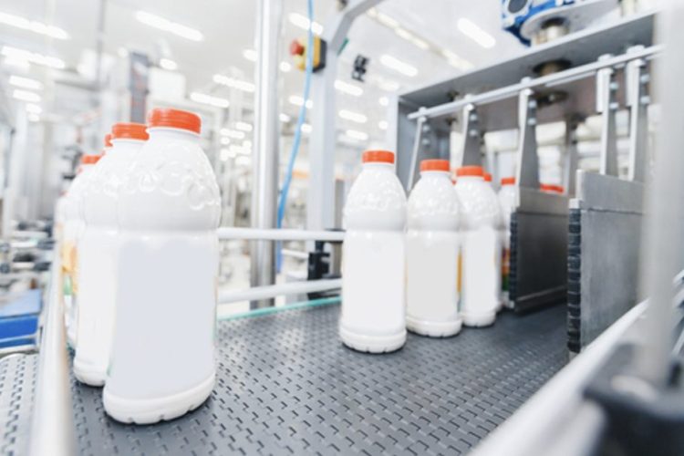 Milk bottles on a production line, illustrating real-time quality control with Process NIR in food manufacturing