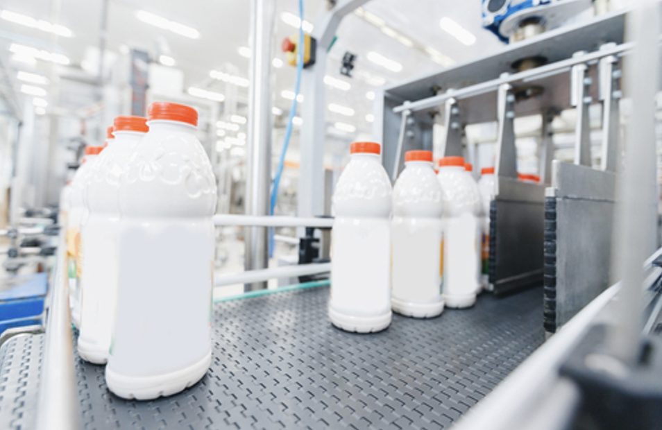 Milk bottles on a production line, illustrating real-time quality control with Process NIR in food manufacturing