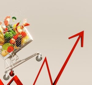 British food price inflation 2025 depicted. An image depicting a shopping cart full of groceries, on the back of an inflation line graph, progressing upwards to depict food costs rising.