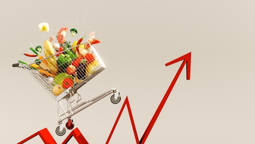 British food price inflation 2025 depicted. An image depicting a shopping cart full of groceries, on the back of an inflation line graph, progressing upwards to depict food costs rising.