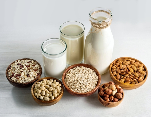 An assortment of alternative protein derived milks, including almond milk, soya milk and pea milk.